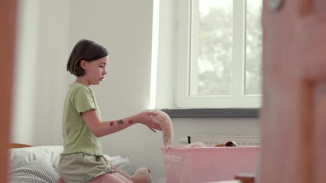 Child cleans up her toys.	
