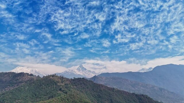 Machhapuchhare (Fishtail) Mountain with Lush Hills and Snow-Capped Peaks Under Dramatic Sky