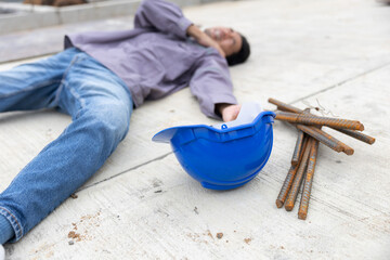 Worker lies on construction site floor with safety helmet suffer from accident