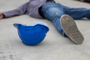 Worker lies on construction site floor with safety helmet suffer from construction accident