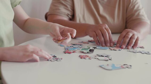 Grandmother and granddaughter doing puzzle at home.	