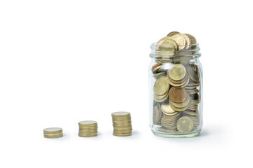 Glass Jar Filled with Coins and Stacks Representing Savings Growth