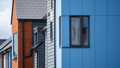 Colorful townhouse with combination of red brick and modern blue panel cladding in urban housing area