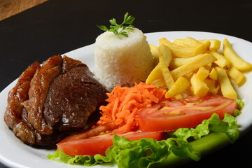 Picanha grelhada, servida com batatas fritas e salada