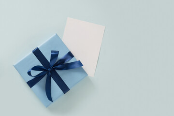 Blue gift box and empty white blank on plain pastel blue background. Flat lay. Happy Fathers Day....