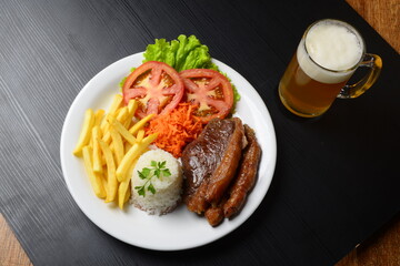 Picanha grelhada, servida com batatas fritas e salada