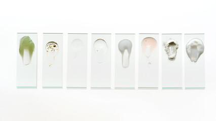 Textures of various cosmetic products on slides in one row.