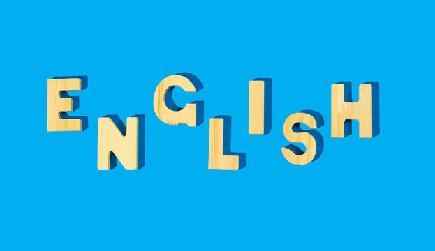 The word English - wooden letters on a blue background. Language learning or teaching.