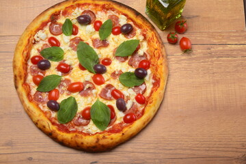 Pizza paulista, molho tomate, mozzarella, calabresa, tomate cereja, azeitonas pretas e manjericão