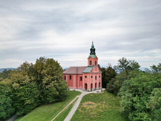 view of small colorful hilltop church at dusk with cloudy overcast sky (beautiful catholic...