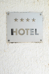 Four-star hotel sign on white textured wall. Travel accommodation rating, tourism concept, and hospitality industry symbol.