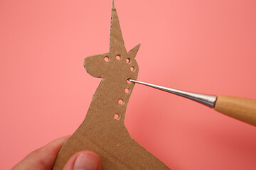 Cardboard horse puppet with punched mane for creative DIY project, useful for kids crafts, art...
