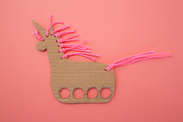 Educational DIY unicorn puppet made from cardboard and yarn for kids creative development, preschool activities, handmade toy branding, teacher resources, arts and crafts stores,