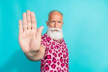 Portrait of funky aged man arm show stop wear leopard print costume isolated on turquoise color...