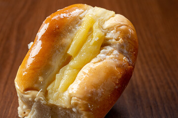Sweet bread:
Sweet buns with vanilla cream on the brown wooden table and black background