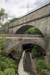 Fototapeta premium famous double arch bridge over stream in ossining new york (sing sing kill rail path old croton aqueduct) road crossing two arches