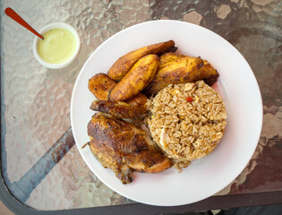 peruvian fried chicken dish with pork and egg fried rice fried sweet plantains and spicy green sauce (peru cuisine restaurant special meal ossining new york) white plate rotisserie pollo asian fusion