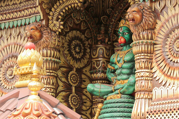 Close-up of Detailed Decorative Carving of Hindu Temple with Hanuman Statue in Lotus Pose on Tail in Malaysia