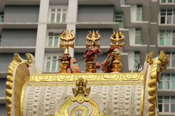 Golden Shiva Tridents on Hindu Temple Dome in Kuala Lumpur with Urban Skyscraper Background