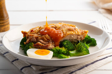 Healthy Diet High Protein Low Fat,zero oil Air fryer Grilled Chicken thighs with boiled egg and broccoli in white plate.It's crispy on skin and soft on the inside.