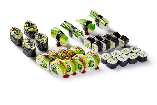 Vegan sushi set with cucumber, avocado and sesame seeds drizzled with soy sauce on white background