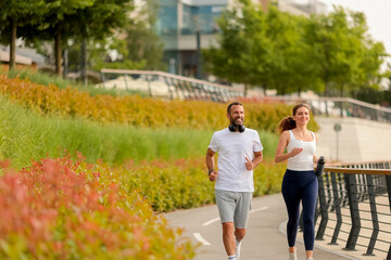 Morning jogs bring joy and energy to an urban park with vibrant foliage and happy conversations