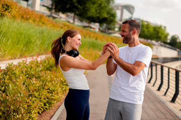 Couple enjoys a joyful moment while exercising together in a scenic park during a sunny afternoon