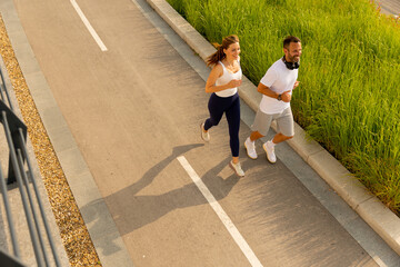 Joyful morning joggers enjoying the sunshine along a scenic pathway surrounded by green grass and vibrant nature