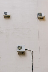 Air conditioning on facade of building and windows in the southern hot country. facade of yellow house on a city street. Escape from the heat, creating a favorable microclimate in urban conditions.