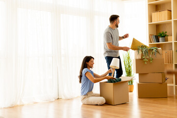Couple unpacks boxes together in bright living room, creating a cozy new home full of warmth and excitement during the afternoon