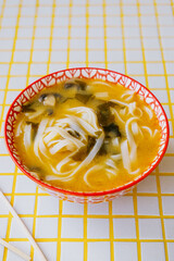 plate of noodles and chopsticks. vegetable ramen in a bright blue plate. Asian dishes, spicy miso...