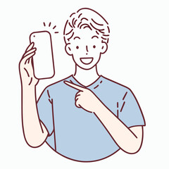 Smiling young man points to the blank smartphone he is holding happily