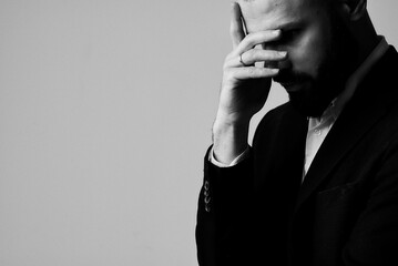 A portrait of a stressed businessman, lost in thought in black and white