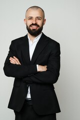 Successful businessman in a black suit smiles confidently for the camera, professional and ready.