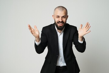 A smiling businessman with a beard gestures with his hands enthusiastically.
