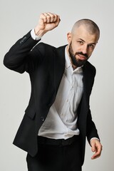 A confident businessman in a suit raises his fist towards the viewer.
