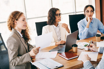 Fototapeta premium Group of professionals collaborating during a business meeting in a corporate office environment, discussing work projects