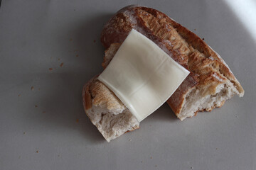A broken baked baguette with melted cheese.