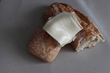 A broken baked baguette with melted cheese.