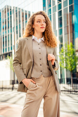 Obraz premium Confident businesswoman outdoors in stylish formal attire enjoying a sunny day in the city for professional endeavors