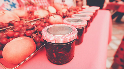 Glass jars filled with homemade jams, pickles, and preserved vegetables.