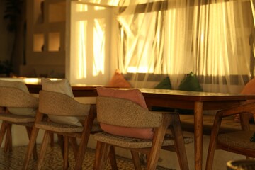 Wooden table and chairs near window indoors