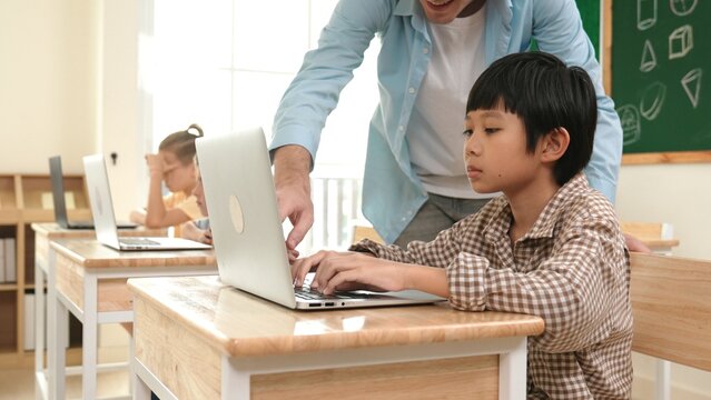 Caucasian teacher helping asian student coding engineering prompt while diverse student using software generated AI. Smart happy attractive children sitting and programing system. Education. Pedagogy. - Powered by Adobe