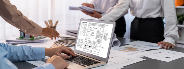 Group of interior architect designer discussing together on blueprint and laptop screen display...