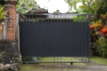 Blurred view of closed gate and green plants
