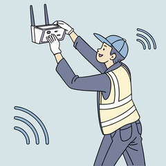 Wireless internet installation in progress with a technician fixing a router on a blue wall in a modern interior.