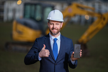 Worker in suit and helmet. Investor civil engineer, construction manager. Construction building developer at a construction site. Successful architect. Handsome hispanic builder man in suit.