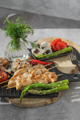 Barbecue on bamboo sticks. Grilled chicken kebab with mushrooms, asparagus and tomato. Red hot kebab.