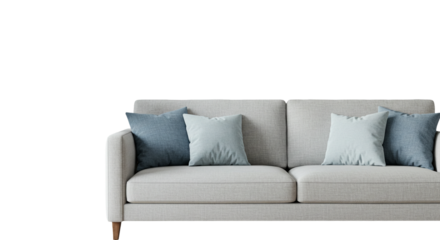 Close up of a white couch with blue and light blue pillows in a dark and bright room setting
