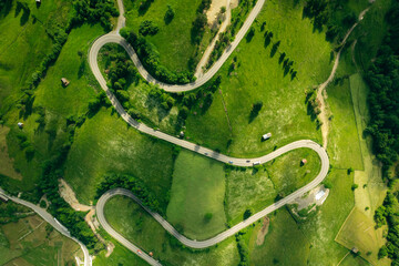 Aerial view of the road passing through the mountain and green forest. Curve asphalt road on mountain forest summer.	
